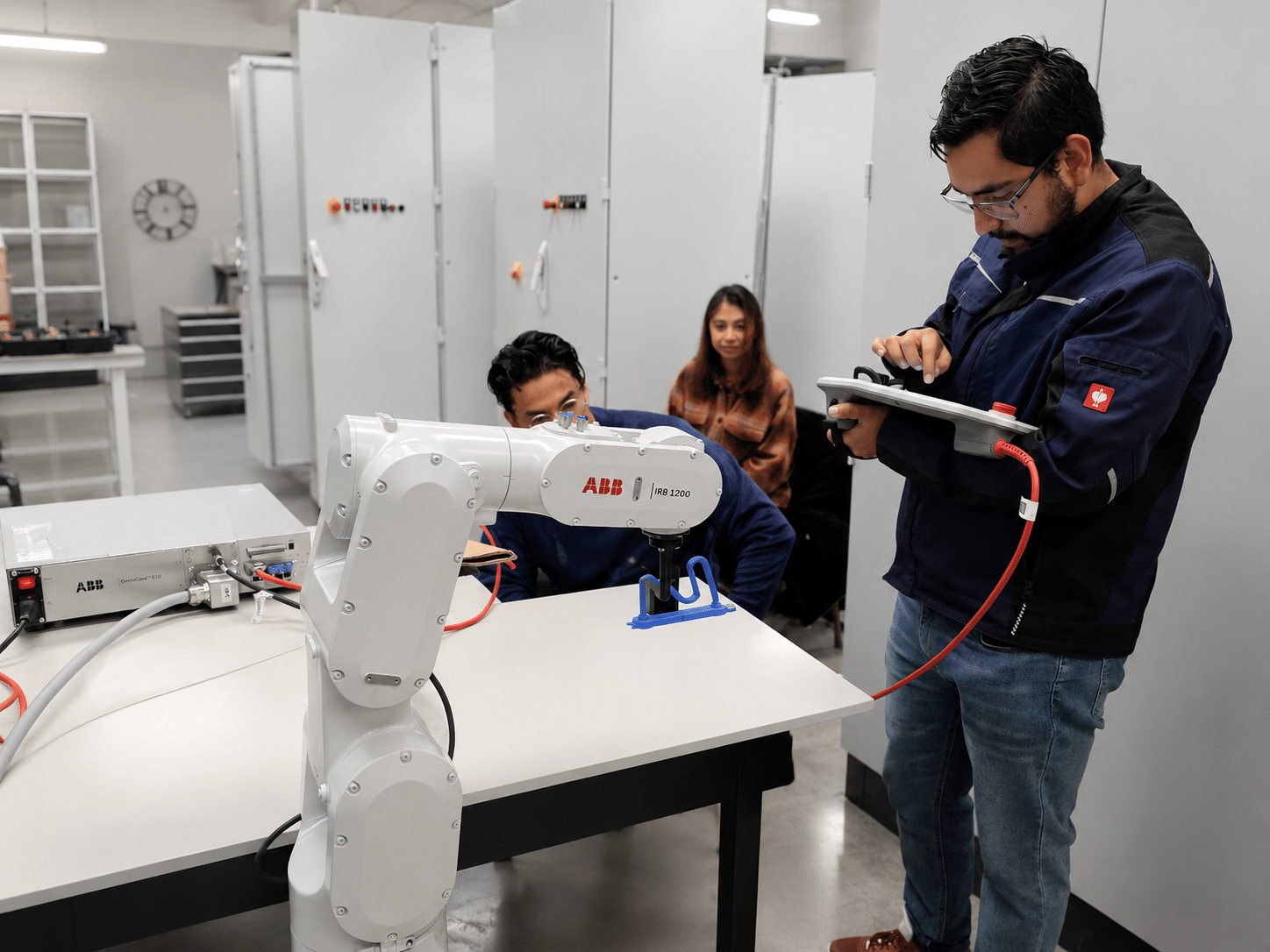 Operador capacitándose en programación de robot industrial